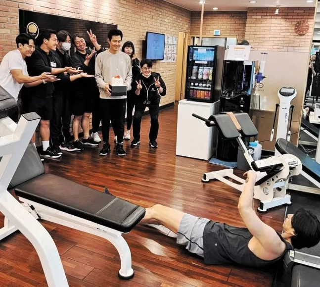 Gong Yoo is taking a picture for Lee Jung-jae at Golden Gym