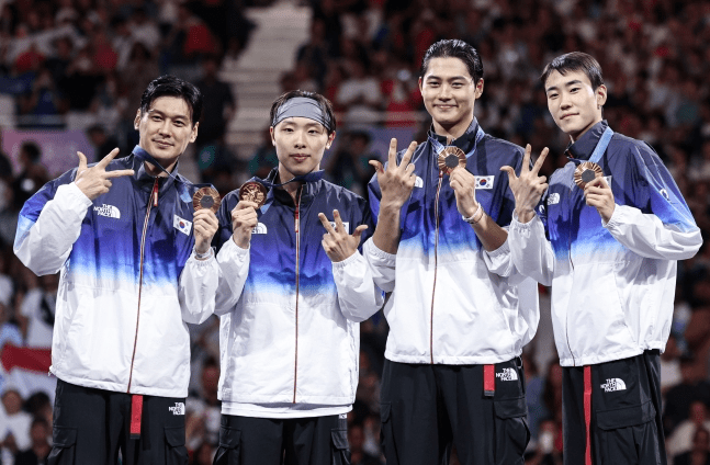 The South Korean fencing team members Gu Bon-gil, Oh Sang-wook, Park Sang-won, and Do Kyung-dong celebrate after receiving their gold medals at the men's sabre team award ceremony at the 2024 Paris Olympics, held at the Grand Palais in Paris, France, on July 31st.